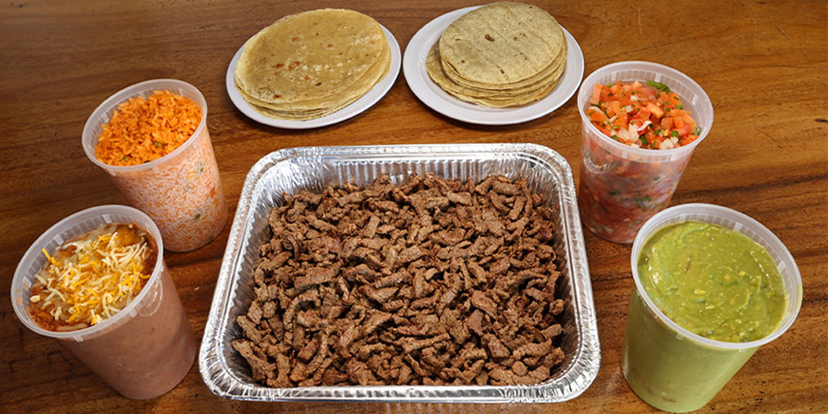 El Pueblo party pack — carne asada tray with tortillas, rice, beans, pico, and guacamole